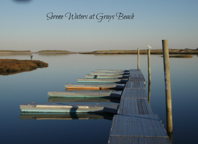 Serene waters at Grays beach. View looking down dock with several small boats.